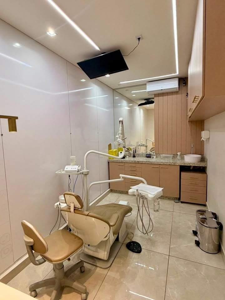 Consultório da Essence com cadeira odontológica, bancada de granito e marcenaria clara